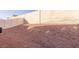 Gravel backyard and tall wall of the property with neighboring houses in the distance at 5045 Bayberry Crest St, North Las Vegas, NV 89031