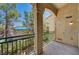 Balcony features a textured post, green metal railing, and view of mature trees and lush greenery at 5155 W Tropicana Ave # 2095, Las Vegas, NV 89103