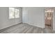 Bedroom with new gray flooring, and bright natural light coming through the window, leading to the bathroom at 5155 W Tropicana Ave # 2095, Las Vegas, NV 89103