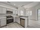 Updated kitchen with stainless steel appliances, gray cabinets, and bar top eating area with natural light at 5155 W Tropicana Ave # 2095, Las Vegas, NV 89103