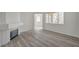 Bright living room featuring wood-look floors, fireplace, and large windows offering natural light at 5155 W Tropicana Ave # 2095, Las Vegas, NV 89103