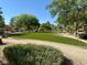 Artificial turf in landscaped community area featuring walking path and mature trees at 5216 Loma Verde Ave, Las Vegas, NV 89108