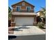 Two-story home featuring a two-car garage, neutral stucco siding, and a well-maintained front yard at 5216 Loma Verde Ave, Las Vegas, NV 89108