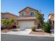 Inviting two-story home featuring a two-car garage, desert landscaping, and a welcoming facade at 5216 Loma Verde Ave, Las Vegas, NV 89108