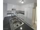 Well-lit kitchen with white cabinetry and backsplash, paired with stainless-steel appliances and dark countertops at 5615 Blue Sea St, Las Vegas, NV 89110