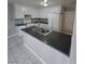 Well-lit kitchen featuring white cabinets, stainless steel sink, and island with dark countertops at 5615 Blue Sea St, Las Vegas, NV 89110