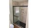 Modern bathroom features a tiled walk-in shower with a black frame at 6470 Shining Sand Ave, Las Vegas, NV 89142