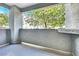 Covered apartment balcony with privacy wall, offering a view of mature trees and the building exterior at 6955 N Durango Dr # 1022, Las Vegas, NV 89149