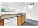 Kitchen boasts a stainless steel sink, wood cabinets, laminate counters, and a view of the living area at 6955 N Durango Dr # 1022, Las Vegas, NV 89149