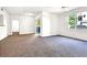 Open living room featuring neutral walls, plush carpet, and sliding glass door to the balcony at 6955 N Durango Dr # 1022, Las Vegas, NV 89149