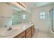 Bright bathroom with double sinks, a large mirror, and a shower/tub combination at 697 Gull Point Ave, Las Vegas, NV 89123