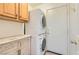 Laundry area showcases a stacked washer and dryer, storage cabinets, and neutral walls at 697 Gull Point Ave, Las Vegas, NV 89123