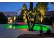 Backyard pool and hot tub with palm trees and shrubs illuminated at night at 697 Gull Point Ave, Las Vegas, NV 89123