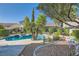 Sparkling pool surrounded by lush landscaping in a well maintained backyard at 697 Gull Point Ave, Las Vegas, NV 89123