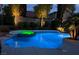 Backyard pool and hot tub are illuminated at night with lush landscaping at 697 Gull Point Ave, Las Vegas, NV 89123