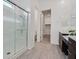 Bathroom featuring dual vanities with stone countertops, dark cabinets, and a walk-in shower at 701 Webber Park St, Henderson, NV 89011