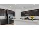 Modern kitchen with stainless appliances, an island with white countertop, and dark cabinetry at 701 Webber Park St, Henderson, NV 89011