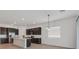 Bright kitchen features dark cabinetry, a large island, and stainless steel appliances at 701 Webber Park St, Henderson, NV 89011