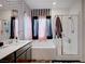 Bright bathroom featuring patterned wallpaper, modern vanity, bathtub, and glass-enclosed shower at 7109 Red Gulch St, North Las Vegas, NV 89084