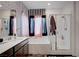 Bathroom featuring shower over tub with glass screen and peach and black decorations at 7109 Red Gulch St, North Las Vegas, NV 89084