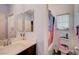 Cozy bathroom features a dual mirror, vanity, and a toilet with colorful tropical themed seat cover at 7109 Red Gulch St, North Las Vegas, NV 89084