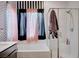 Bright bathroom featuring striped wallpaper, modern bathtub and glass-enclosed shower at 7109 Red Gulch St, North Las Vegas, NV 89084