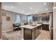 Modern eat-in kitchen featuring dark cabinetry, an island with sink, and stainless steel appliances at 7109 Red Gulch St, North Las Vegas, NV 89084