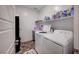 Functional laundry room with modern washer and dryer, and ample storage shelving at 7109 Red Gulch St, North Las Vegas, NV 89084