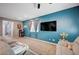Inviting living room with blue accent wall, large television, and comfortable seating at 7109 Red Gulch St, North Las Vegas, NV 89084