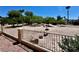 View of the backyard featuring rocks and greenery, partially enclosed by a metal fence on a sunny day at 7273 Vista Bonita Dr, Las Vegas, NV 89149