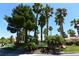 Community sign for Sandpiper Golf Villas surrounded by palm trees, desert landscape, and green grass on a sunny day at 7273 Vista Bonita Dr, Las Vegas, NV 89149