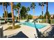 Community pool area featuring palm trees, lounge chairs, tables, and a large in-ground swimming pool on a sunny day at 7273 Vista Bonita Dr, Las Vegas, NV 89149