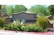 Painted Desert entrance sign with lush desert plants, vibrant red flowers and agave at 7273 Vista Bonita Dr, Las Vegas, NV 89149