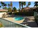 A community hot tub area featuring palm trees, lounge chairs, tables, and an in-ground hot tub on a sunny day at 7273 Vista Bonita Dr, Las Vegas, NV 89149
