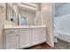 A bathroom with white cabinets, a large mirror, and a shower/tub combo at 7606 Kenwood Hills Ct, Las Vegas, NV 89131