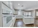 Spacious kitchen featuring a center island, white appliances and cabinets, and a tile backsplash at 7606 Kenwood Hills Ct, Las Vegas, NV 89131