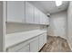 This laundry room features white cabinets and tile flooring at 7606 Kenwood Hills Ct, Las Vegas, NV 89131