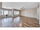 Spacious living room with wood-look floors, neutral paint, modern ceiling fan, and lots of windows at 7606 Kenwood Hills Ct, Las Vegas, NV 89131