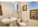 Charming powder room featuring a pedestal sink, wall cabinet, and decorative wall art at 7702 Wishbone Falls St, North Las Vegas, NV 89084