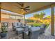 Comfortable covered patio with ceiling fan and outdoor furniture overlooks a pristine backyard at 7702 Wishbone Falls St, North Las Vegas, NV 89084