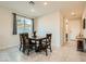 Dining room with a wooden table, four chairs, and natural light from the window at 7702 Wishbone Falls St, North Las Vegas, NV 89084