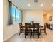 Dining room featuring a wooden table with seating for four and a large window at 7702 Wishbone Falls St, North Las Vegas, NV 89084