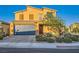 Charming two-story home featuring a tile roof, two-car garage, and desert landscaping under a clear blue sky at 7702 Wishbone Falls St, North Las Vegas, NV 89084