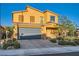 Two-story home featuring a tile roof, desert landscaping, and a two-car garage with a paved brick driveway at 7702 Wishbone Falls St, North Las Vegas, NV 89084