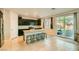 Bright kitchen with stainless steel appliances, dark cabinets, granite counters, and a sliding door to the backyard at 7702 Wishbone Falls St, North Las Vegas, NV 89084
