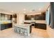 Modern kitchen features a large island with seating, stainless steel appliances, and dark cabinetry at 7702 Wishbone Falls St, North Las Vegas, NV 89084