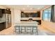 Well-lit kitchen with stainless steel appliances, dark cabinetry, and a granite-topped center island at 7702 Wishbone Falls St, North Las Vegas, NV 89084