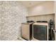 Laundry room has modern washer and dryer and whimsical puppy wallpaper at 7702 Wishbone Falls St, North Las Vegas, NV 89084