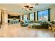 Open-concept living room with tile floors, ceiling fan, and a large comfortable sectional sofa at 7702 Wishbone Falls St, North Las Vegas, NV 89084