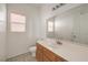 Clean bathroom with white vanity, large mirror, and window at 7977 Blue Brook Dr, Las Vegas, NV 89147